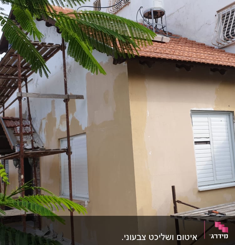 פיגומים ליד קיר עם טיח חדש לאיטום